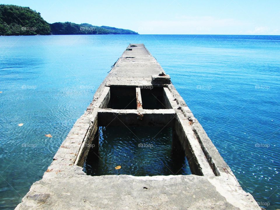 A small pier in a coastal village with large holes.