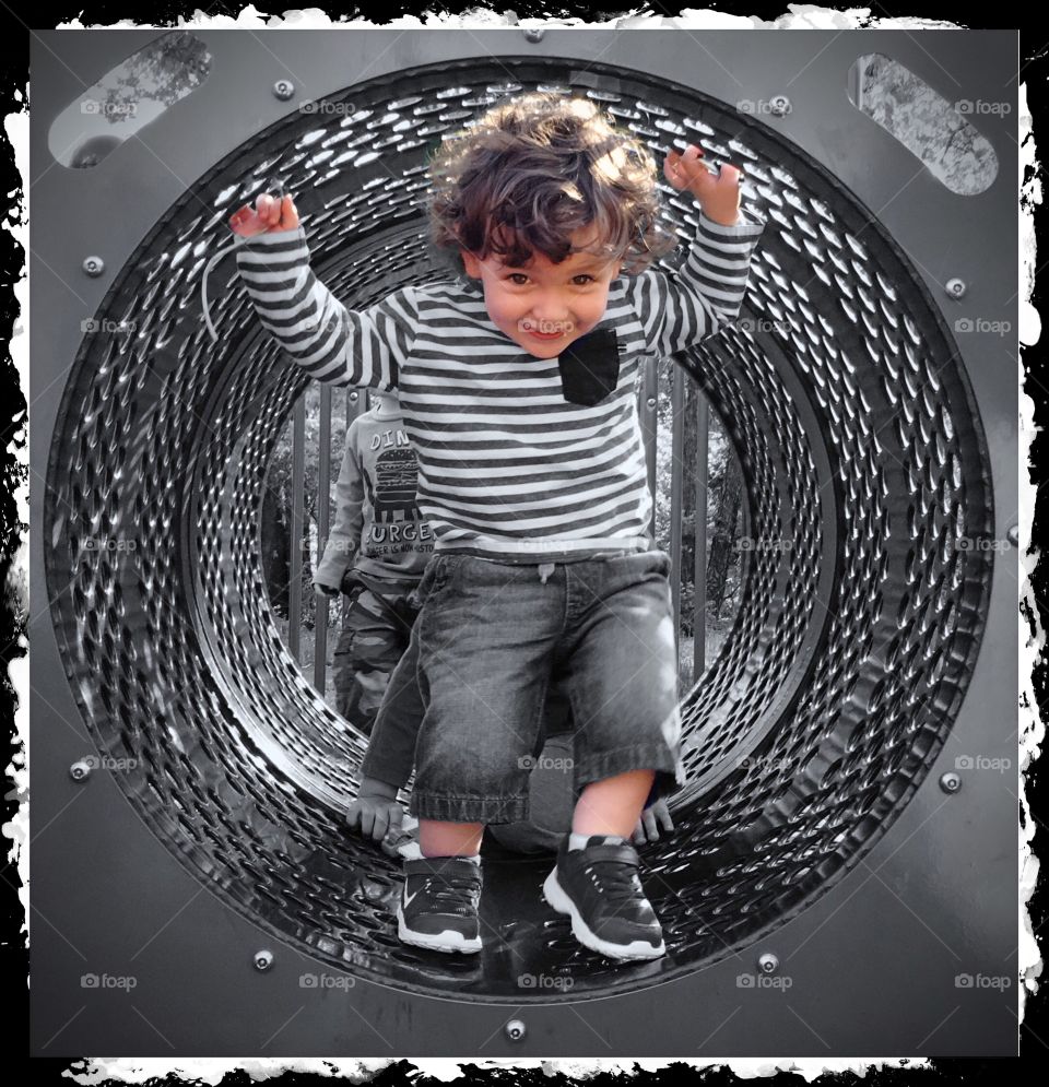 Portrait of a happy boy in tunnel at playground