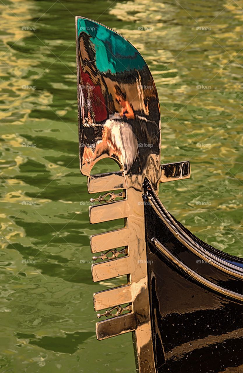 A beautiful woman caught relaxing in the highly polished brass on a Venetian gondola.