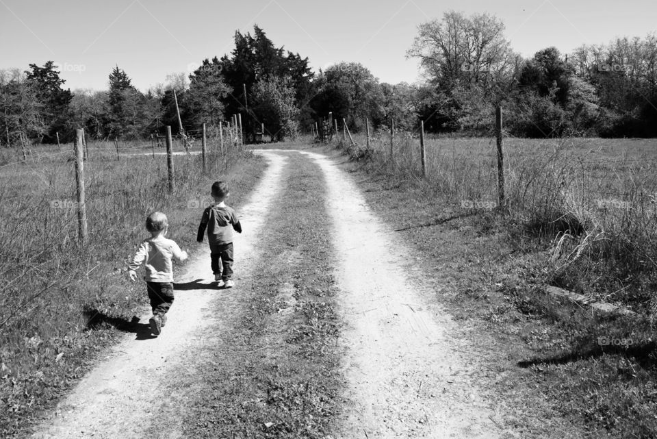 Boys walking on a country dirt road