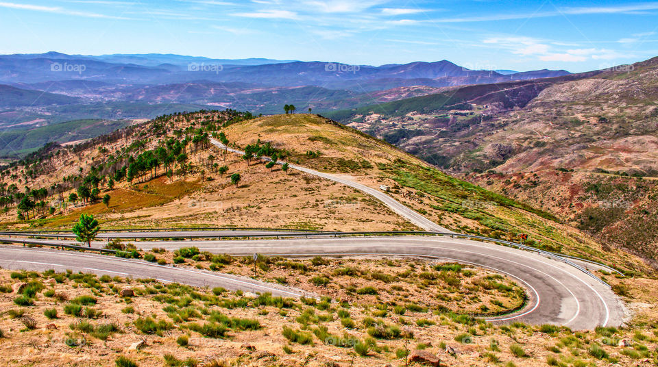 A long, winding road meanders towards the mountains of Serra Da Estrela National Park 