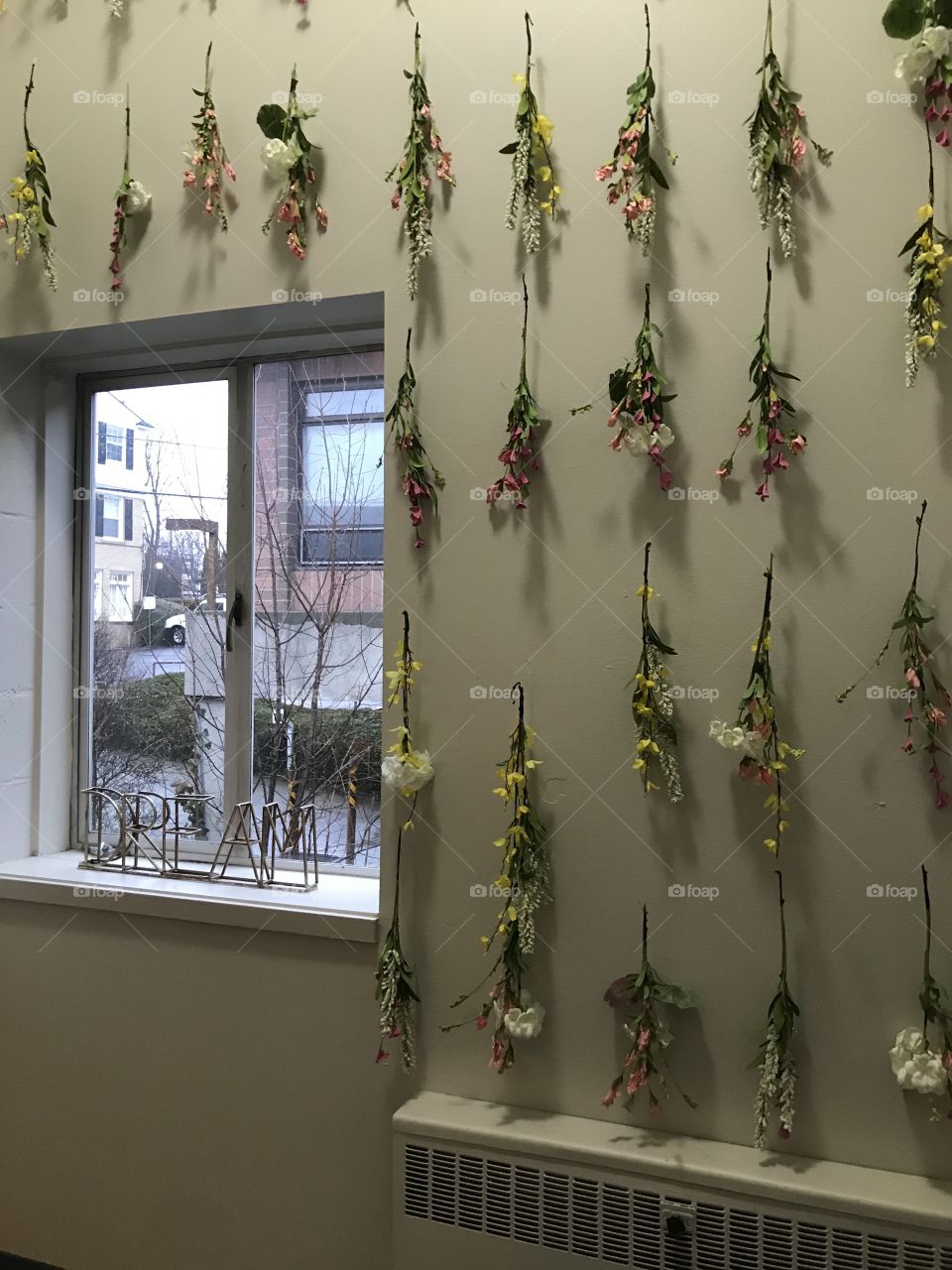Gorgeous backdrop for a wall covered in flowers with a window overlooking a small town street, 
