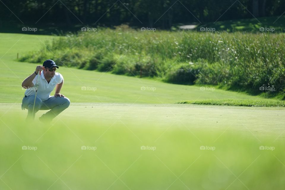 Portrait of a man crouching in golf course