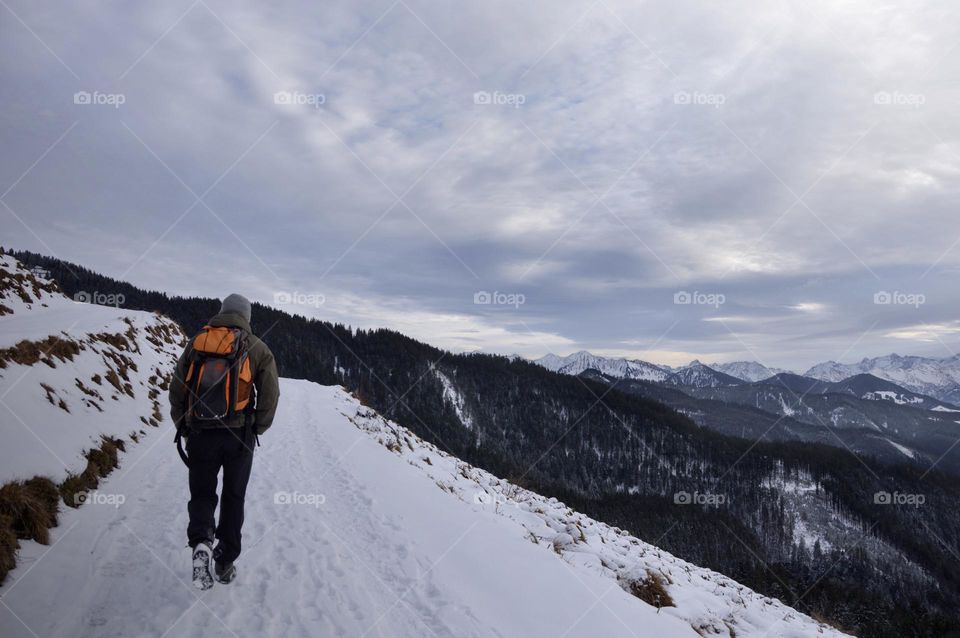 Man hiking in the mountains during winter and snow
