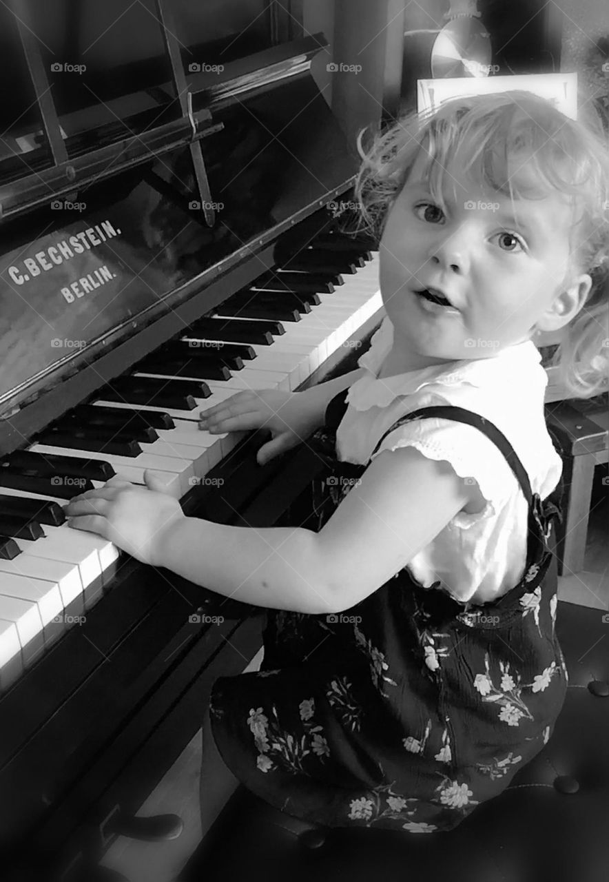 Young child playing the piano and creating lots of noise 