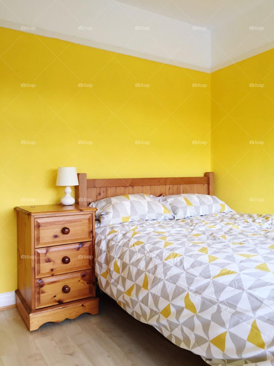 A double bed in a yellow bedroom