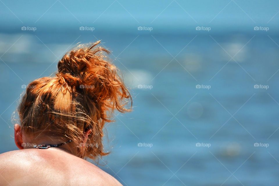 Woman with orange hair at the beach
