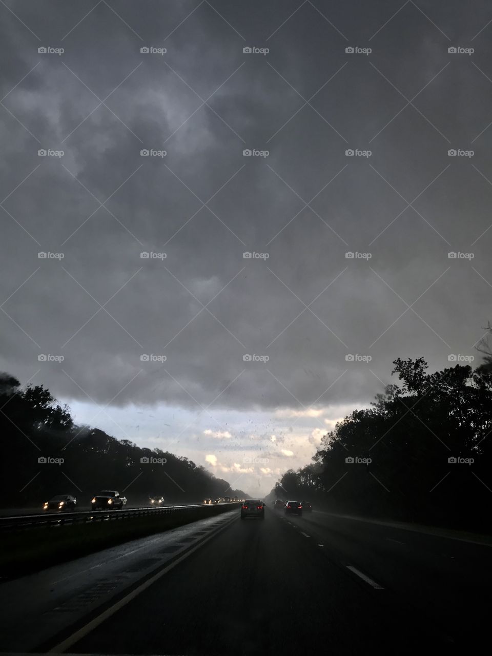 Traveling out of a storm and capturing the dramatic front line of thunder storm clouds and the blue sky ahead 