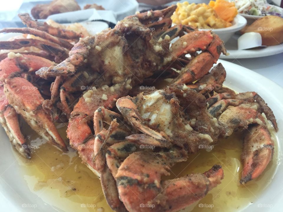A plate of garlic crabs in melted butter.