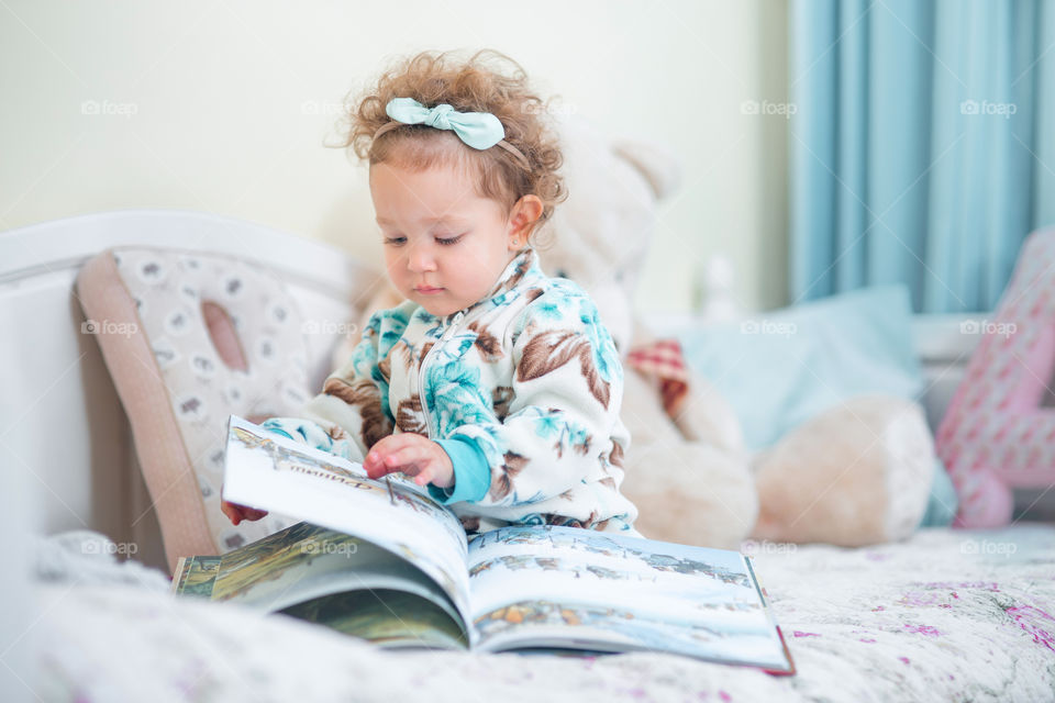 Cute little girl reading a book