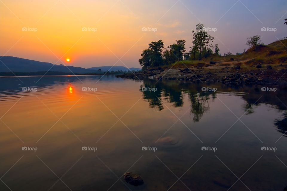 sunrises gracefully by water side illuminating calmness and peace
