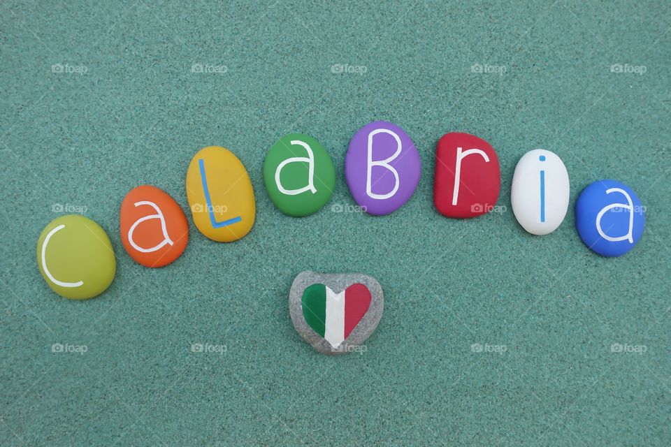 Calabria, italian region in the south of the country, souvenir with colored stones over green sand