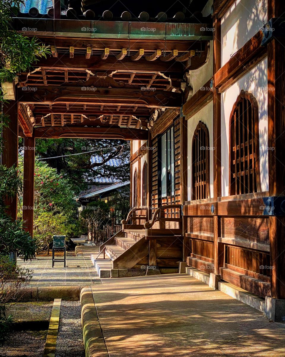 Sunbeam casting light and shadows on ground and wall. A moment of calm and serenity at this temple.