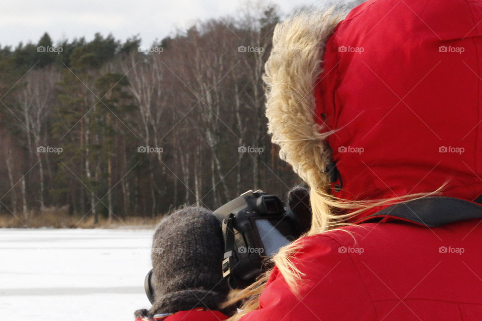 Photographer in red - shooting winter landscape