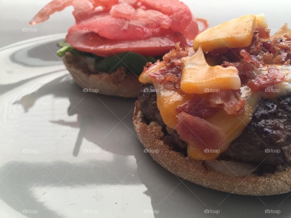 Burger with cheese, bacon, spinach lettuce and tomato on a whole wheat bun English muffin meal dish dinner yum