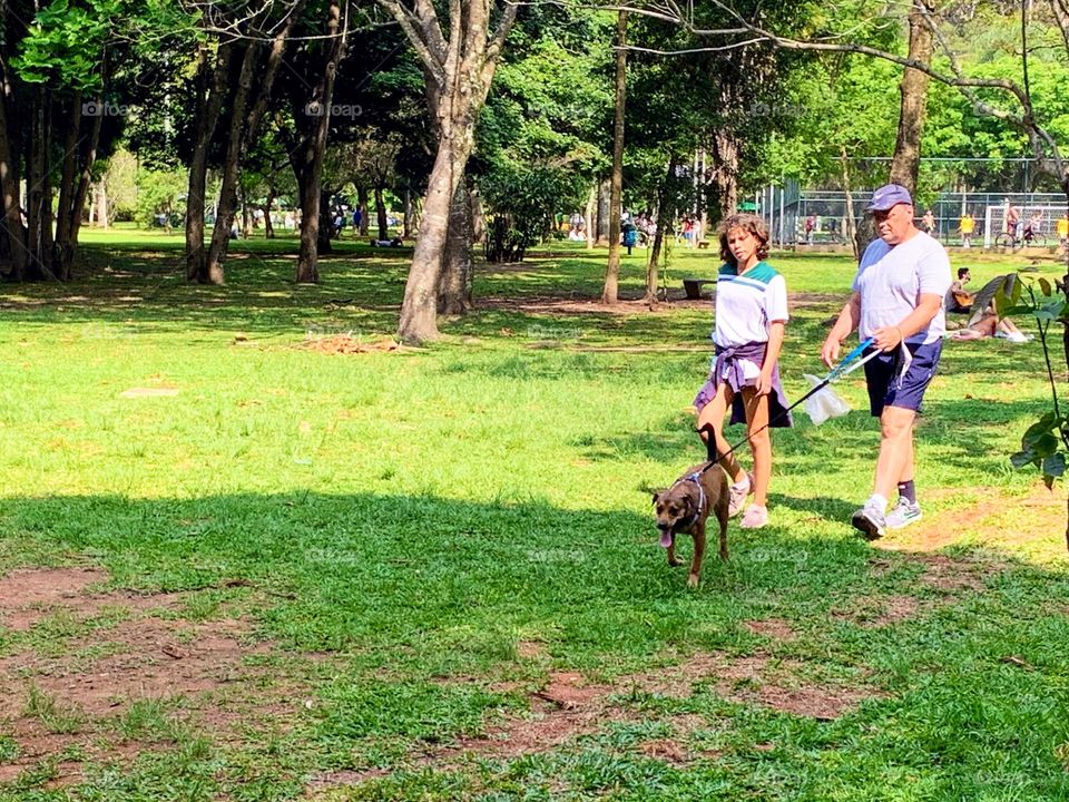 Father and daughter walking their dog in the park