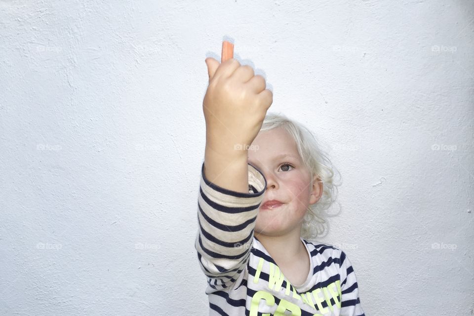 Boy holding up a carrot 