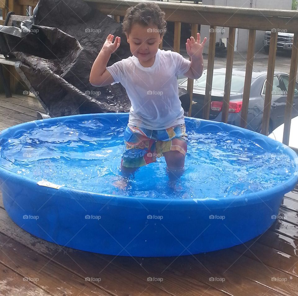 Fun in the Kiddie Pool. boy having fun in his little pool