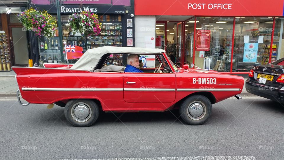 Senior man driving a vintage car in the city