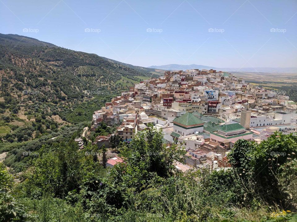 View of the City on the Hillside (Moulay Idriss) in Morocco - Colorful Town surrounded by Green Hills and Mountains - Birds Eye View from Above
