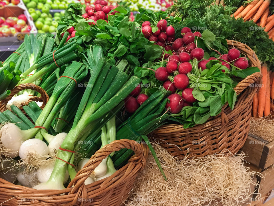 Fresh harvested organically grown vegetables stacked in market stall ready for sale at farmers market.