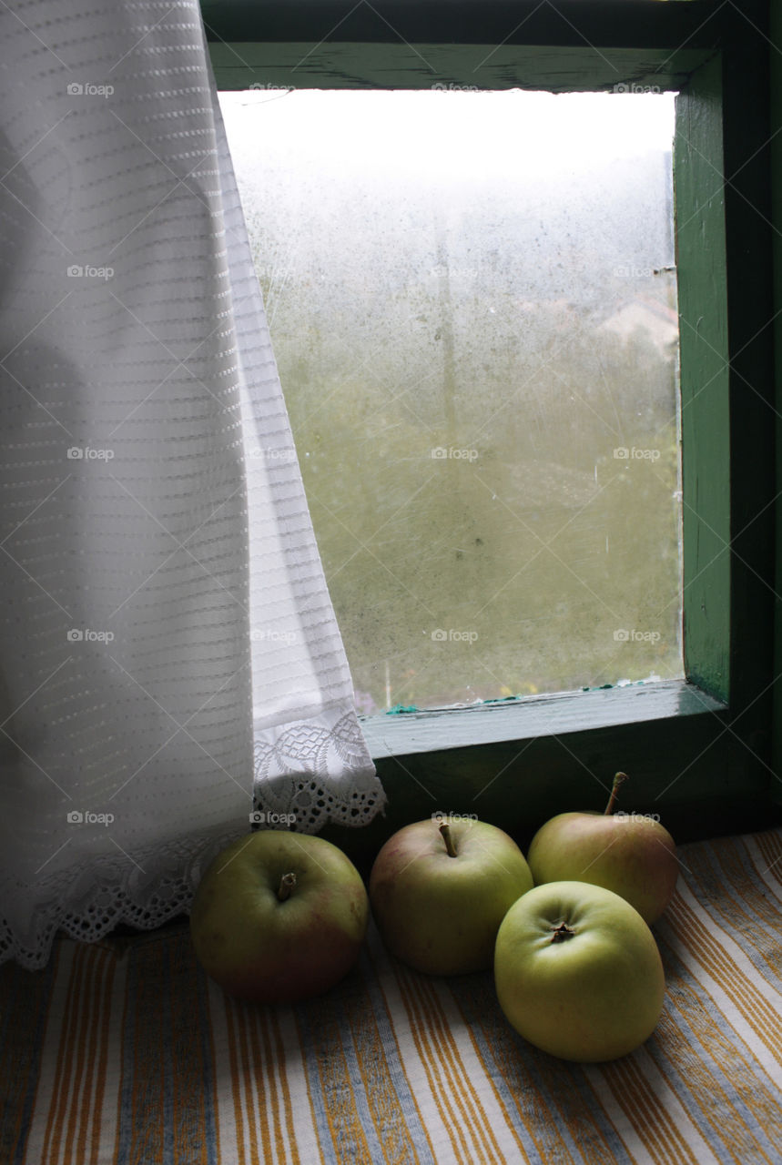 Autumn mood at home. Apples on the window sill, indoor.