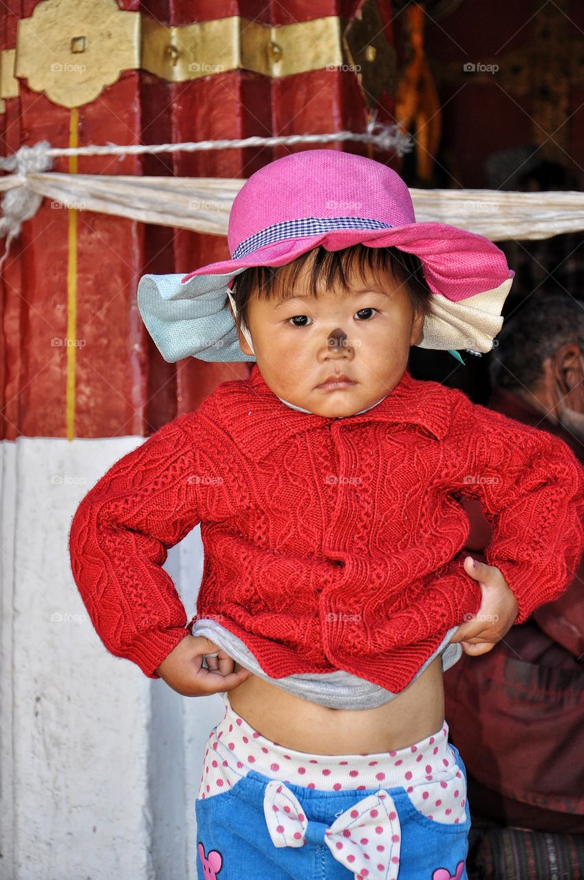 cute little kid in the yard of buddhist monastery near Lhasa in Tibet