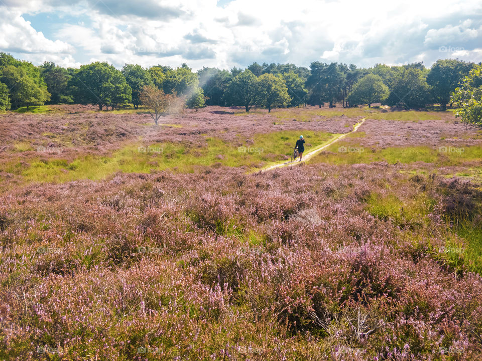 Girl and her bike alone in a heather field