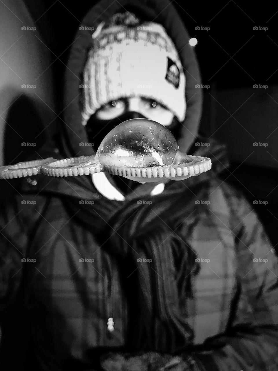 Frozen bubble in the winter, blowing bubbles in the winter, fun with bubbles, woman dressed for winter, outdoor clothes in winter, girl with bubbles, black and white bubbles, monochrome portrait of bubble