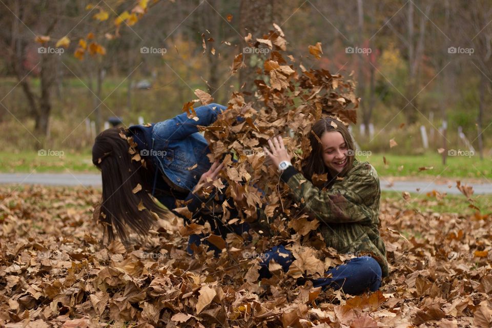 Leaf Fights. Sisterly love! My sisters having fun seeing who can put more leaves on the other.