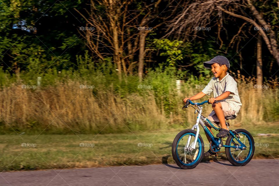 Cute little boy is riding a bicycle in a park