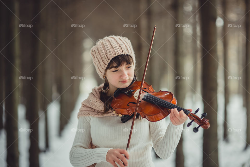 Teenage girl portrait with violin in winter park