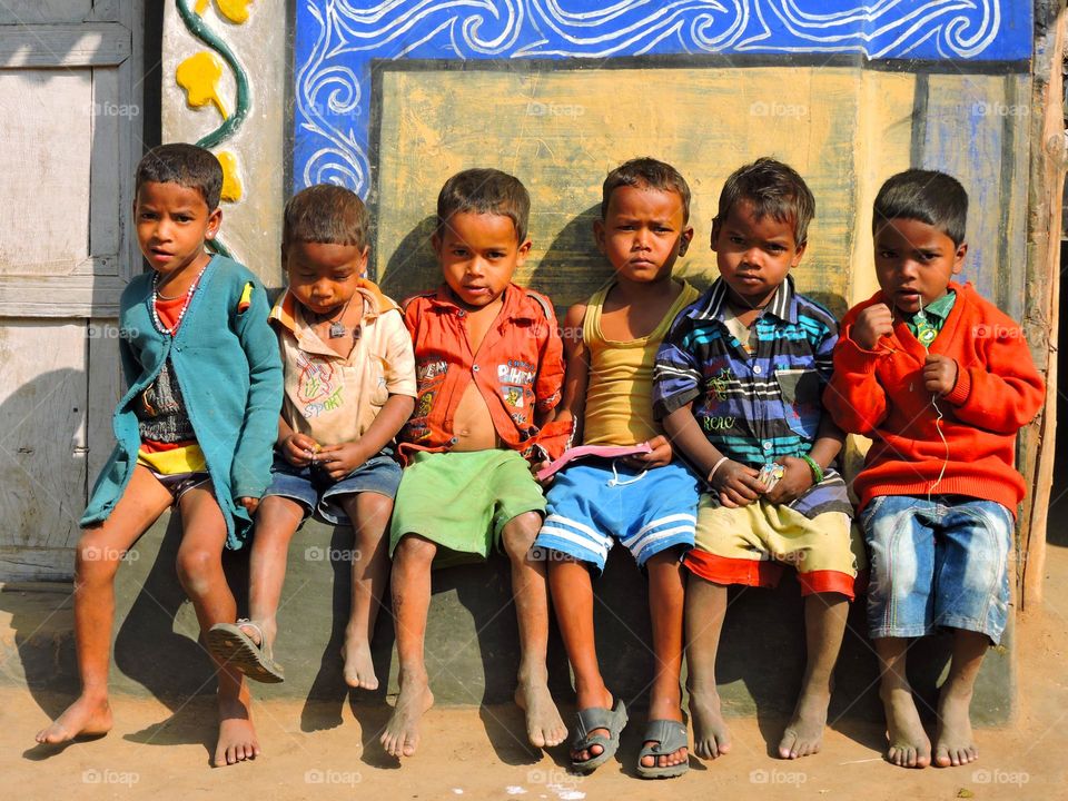 Group of village kids sitting in a row