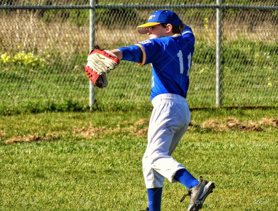 American Little League Baseball. Young Baseball Player Throwing The Ball From Centerfield
