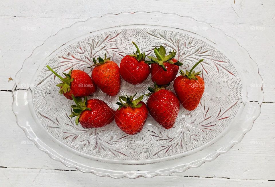 Glass dish full of ripe fresh strawberries 
