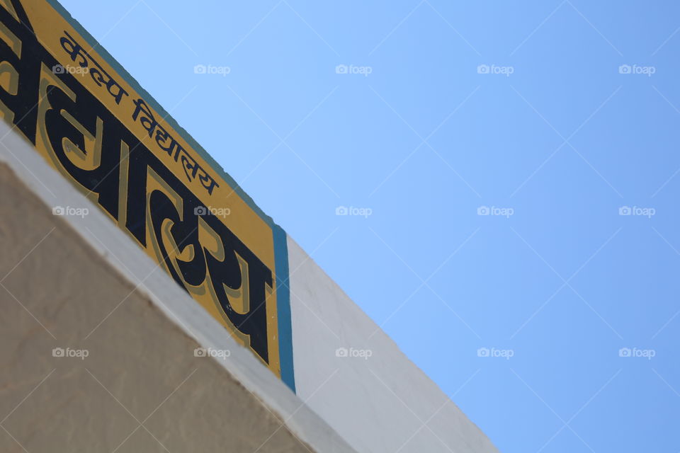 A school sign against a blue sky.