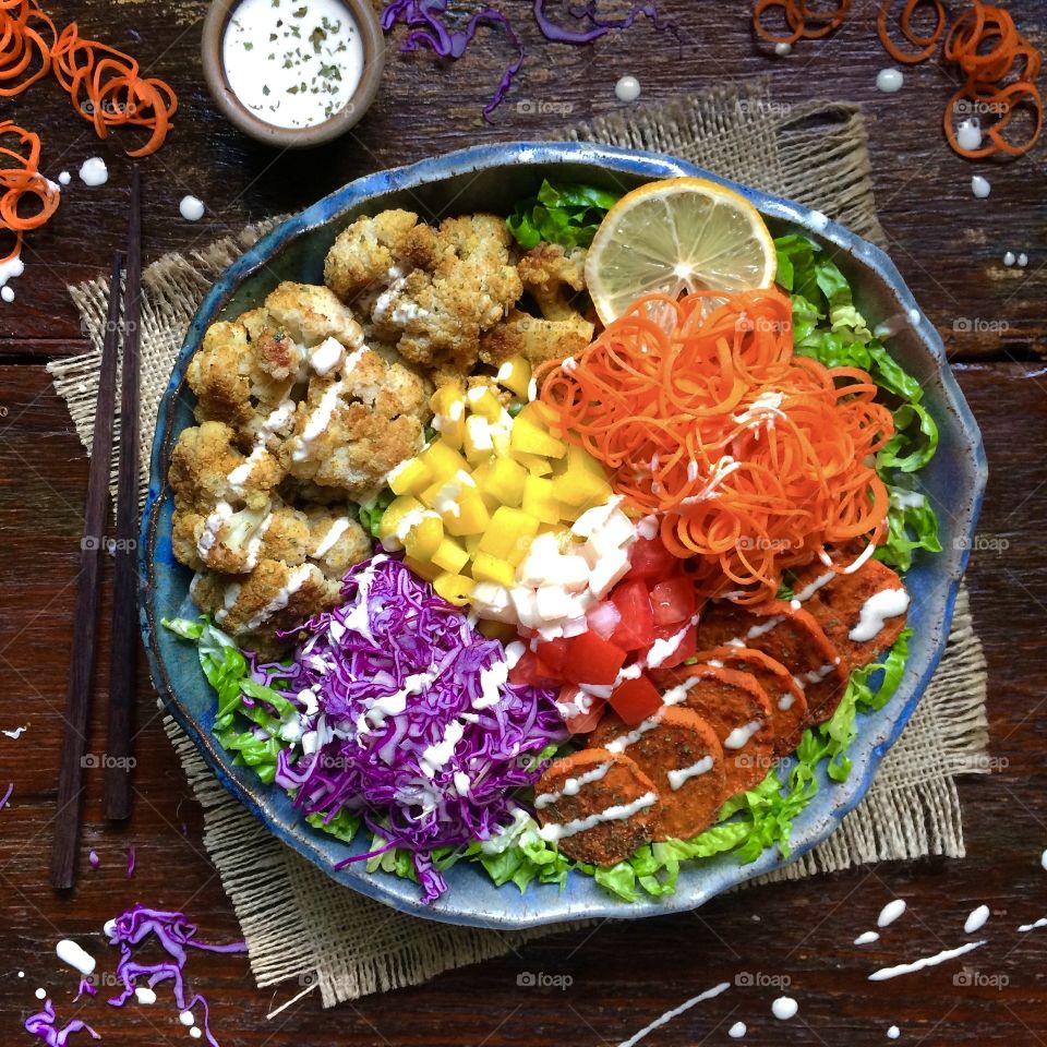 Salad Bowl with roasted cauliflower, spiraled carrots, purple cabbage and sliced sweet potato drizzled with creamy cashew dressing. 