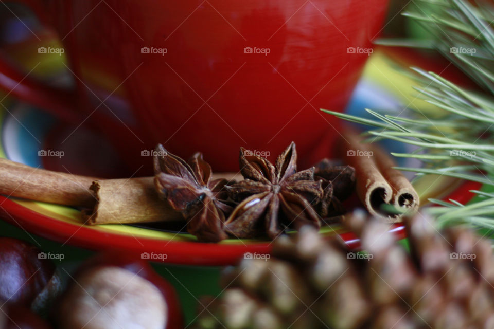 Red cup of coffee with cinnamon and anise, close up 1