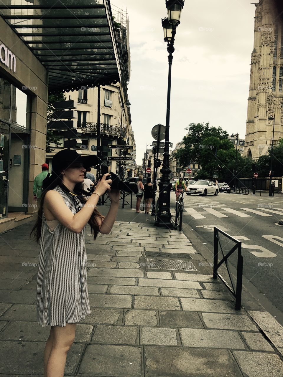 Young woman capturing photo from sidewalk