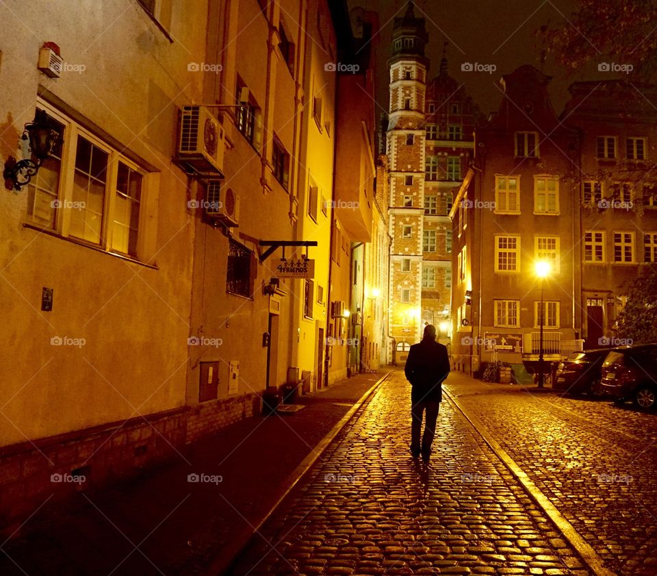 Silhouette of a man (my husband) contrast against  the bright street lights in Gdańsk Poland 