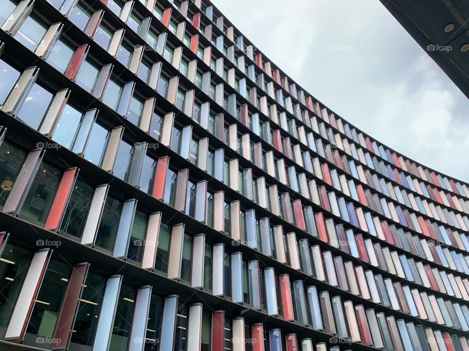 Colourful office building in the city with a cloudy sky