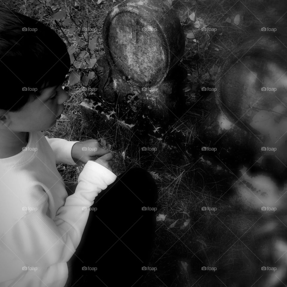 Little boy in front of grave