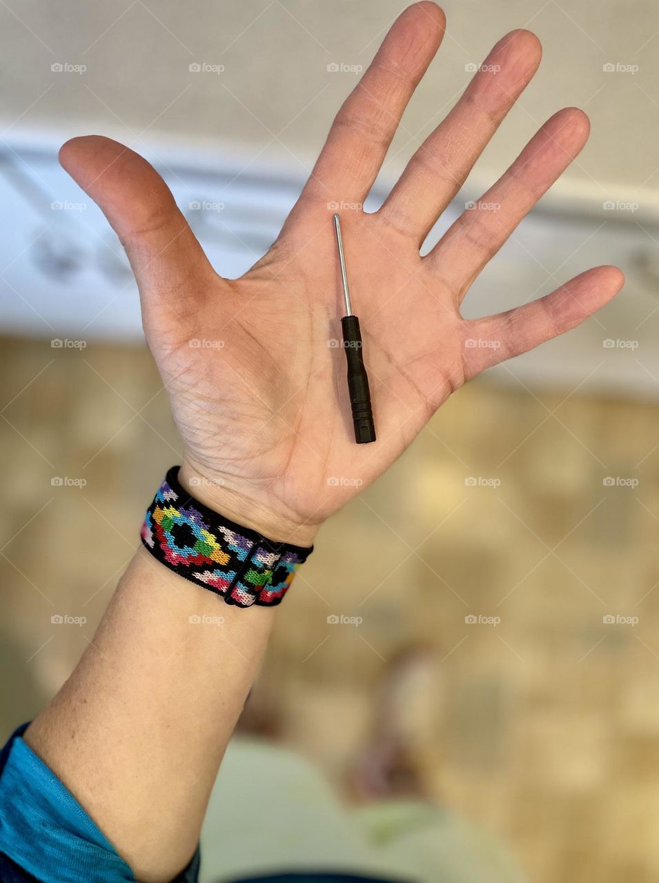 Small screwdriver in woman’s hand, holding small tools, woman’s hand outstretched, Apple Watch accessories 