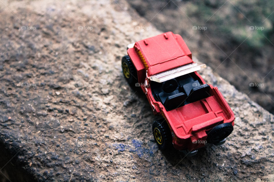 Miniature toy red Jeep on a concrete structure