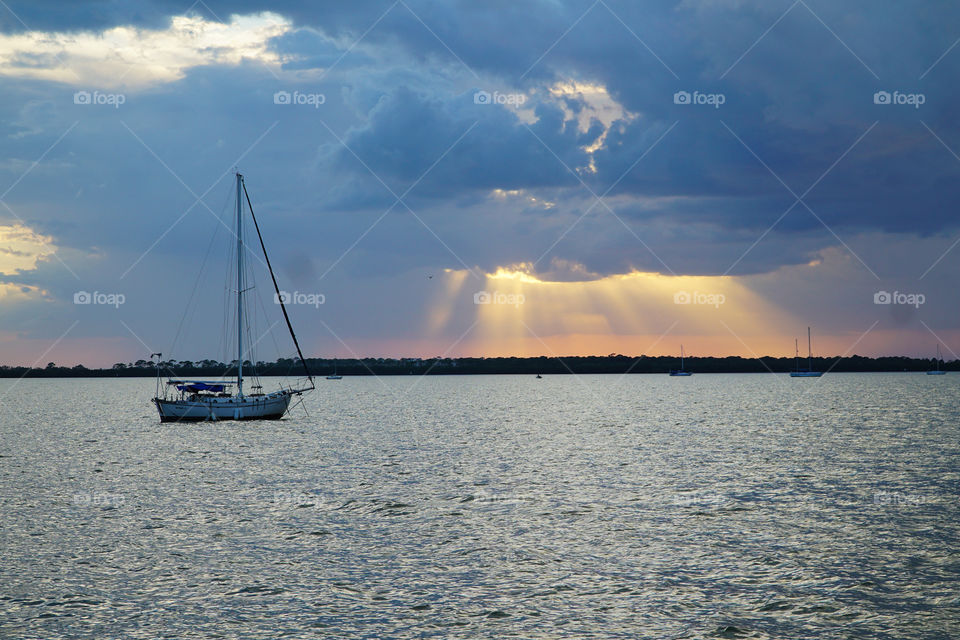 Sun rays through clouds at sunset