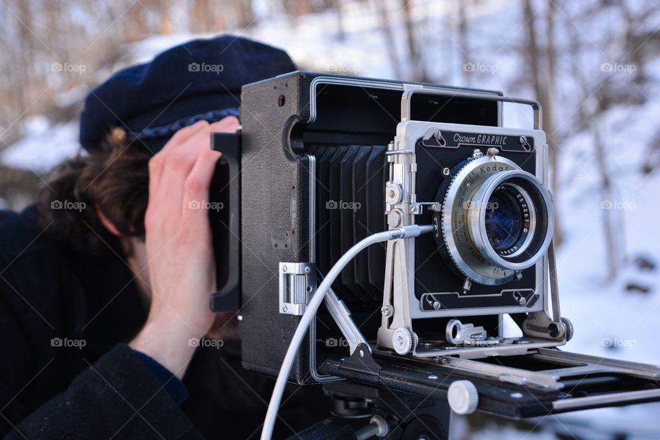 A man uses the old fashion photography equipment of a film camera to capture his image 
