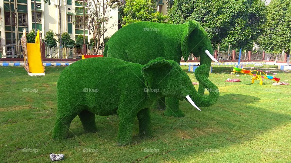 Elephant is made by raw green artificial grass in the chindren park. it is nice to looking of all children.
