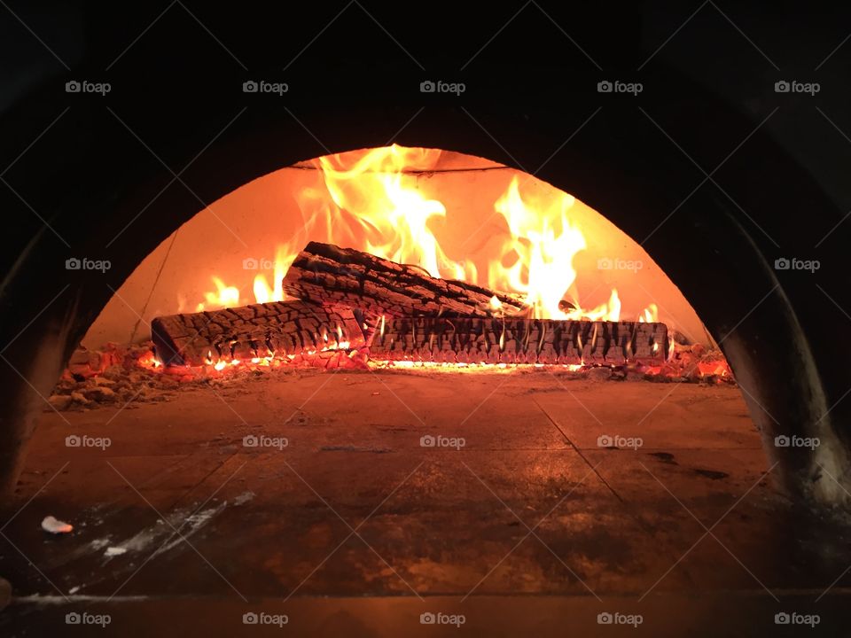 Wood Fire Oven. Same as last different flames dancing, same logs glowing in the back of a Wood fire oven. 