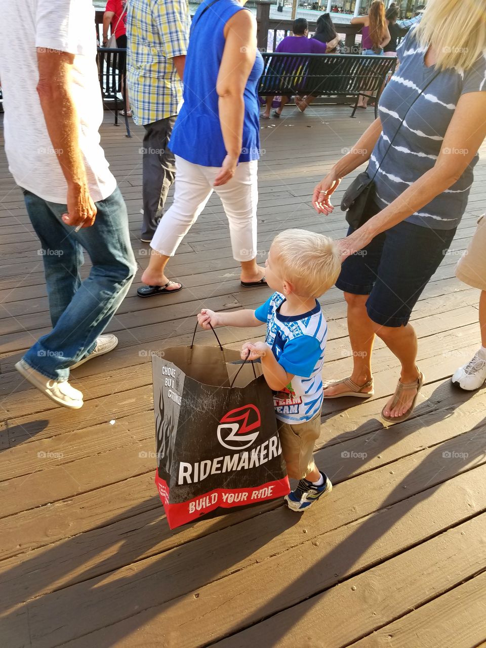 Carrying his new toy down the boardwalk