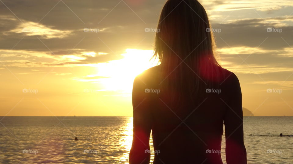 A figure of a woman standing on a sunrise in Vietnam 
